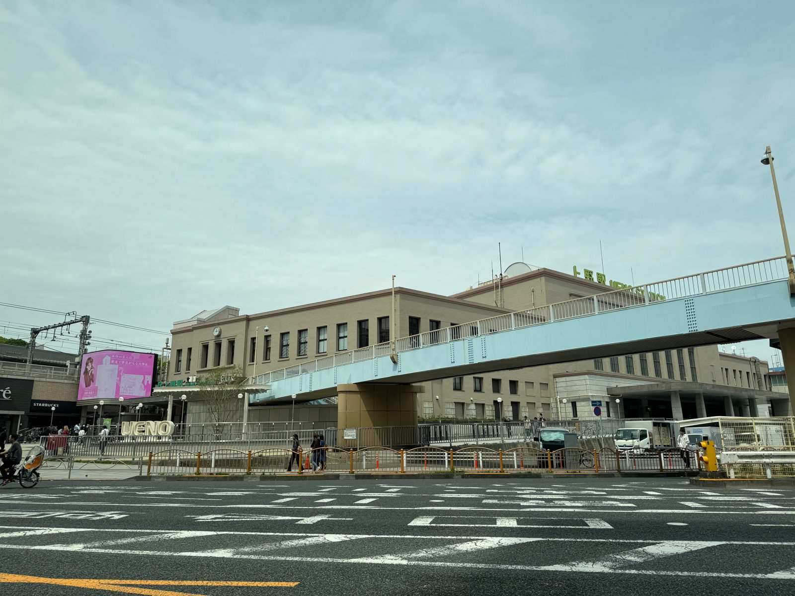 The exterior of Ueno Station in Tokyo with a wide crosswalk in the foreground